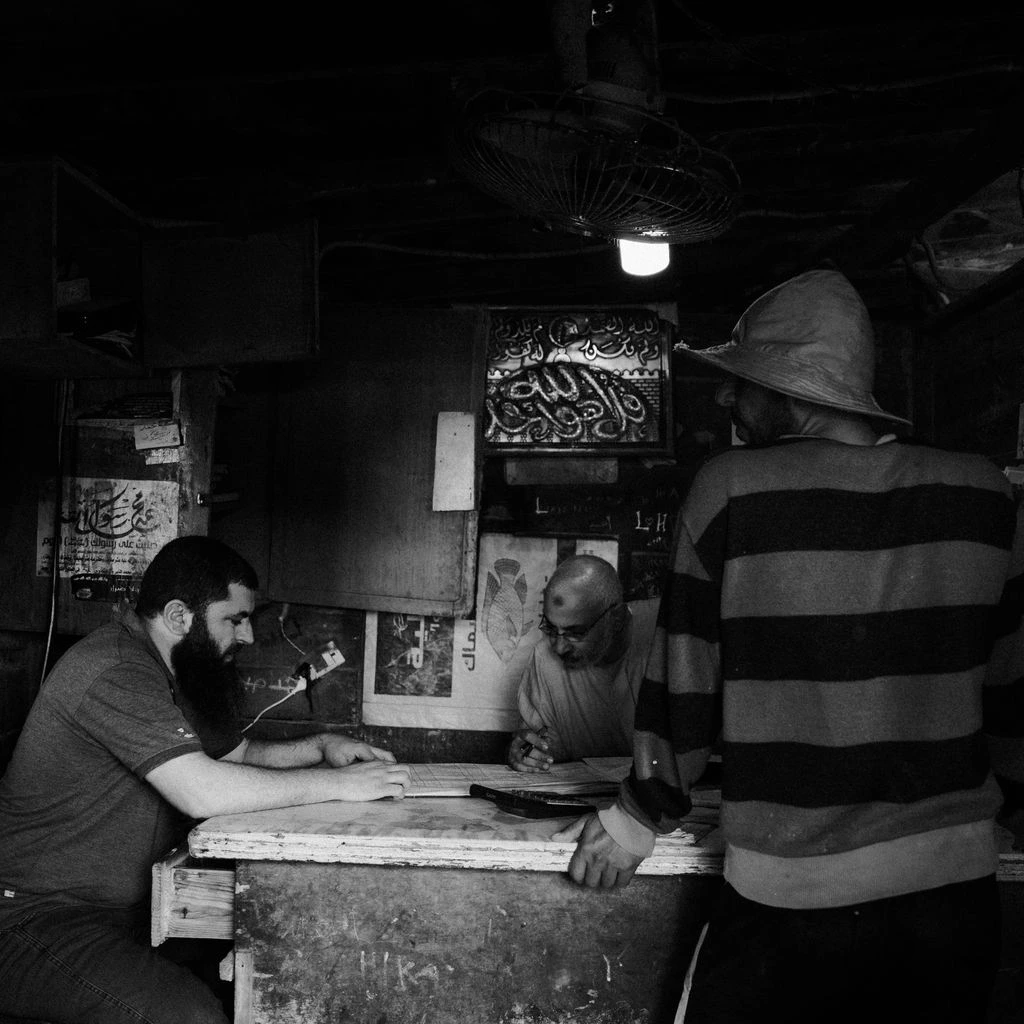 Three Blind Dog pitmasters standing beside the offset smoker at night